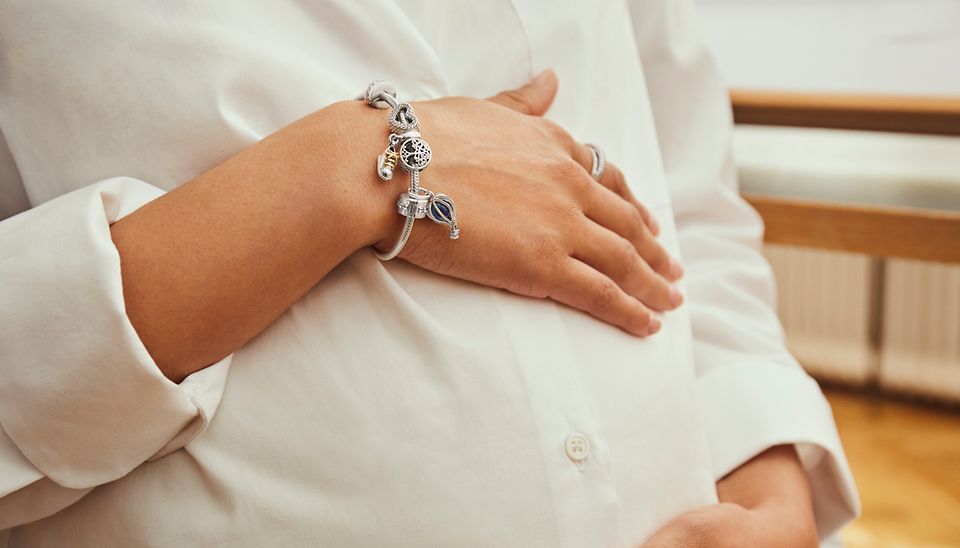 Sterling silver bracelet styled with charms celebrating baby's arrival