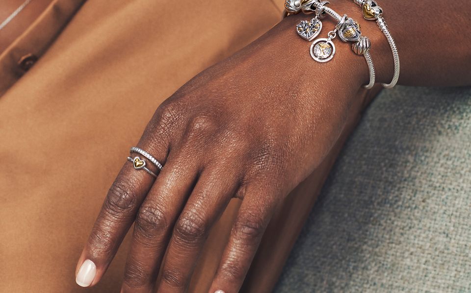 模特佩戴 Pandora Moments 双色戒指、手链及串饰。
