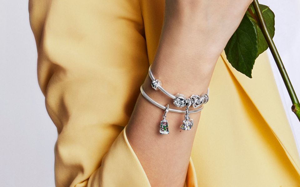 Frau trägt Ring und Armband von „Die Schöne und das Biest“ mit Charms