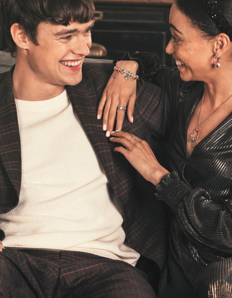 Couple souriant, la femme portant un bracelet Pandora Moments agrémenté de charms