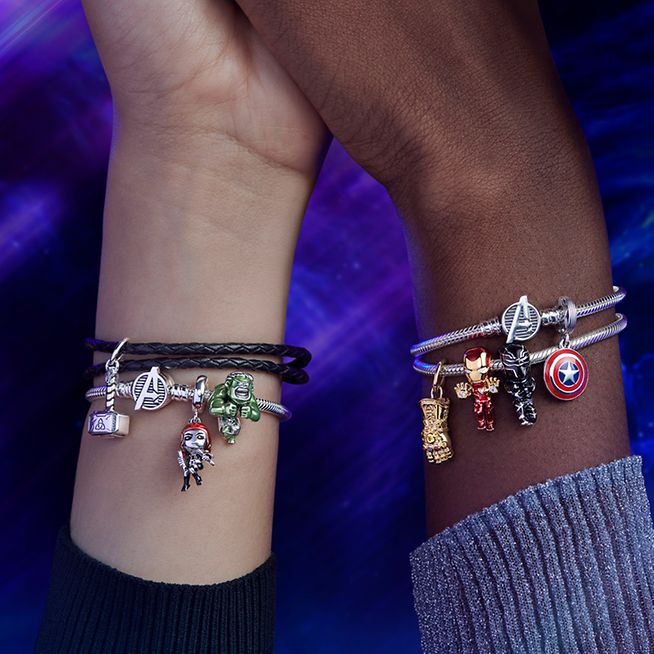 Hands wearing Silver Avengers-inspired bracelets with Marvel heroes charms