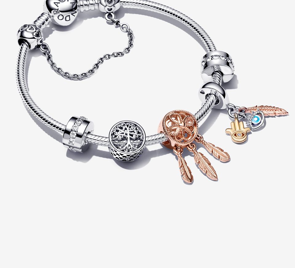 Srebrna bransoletka ozdobiona charmsami ze srebra, charmsami platerowanymi różowym złotem oraz srebrnym łańcuszkiem zabezpieczającym