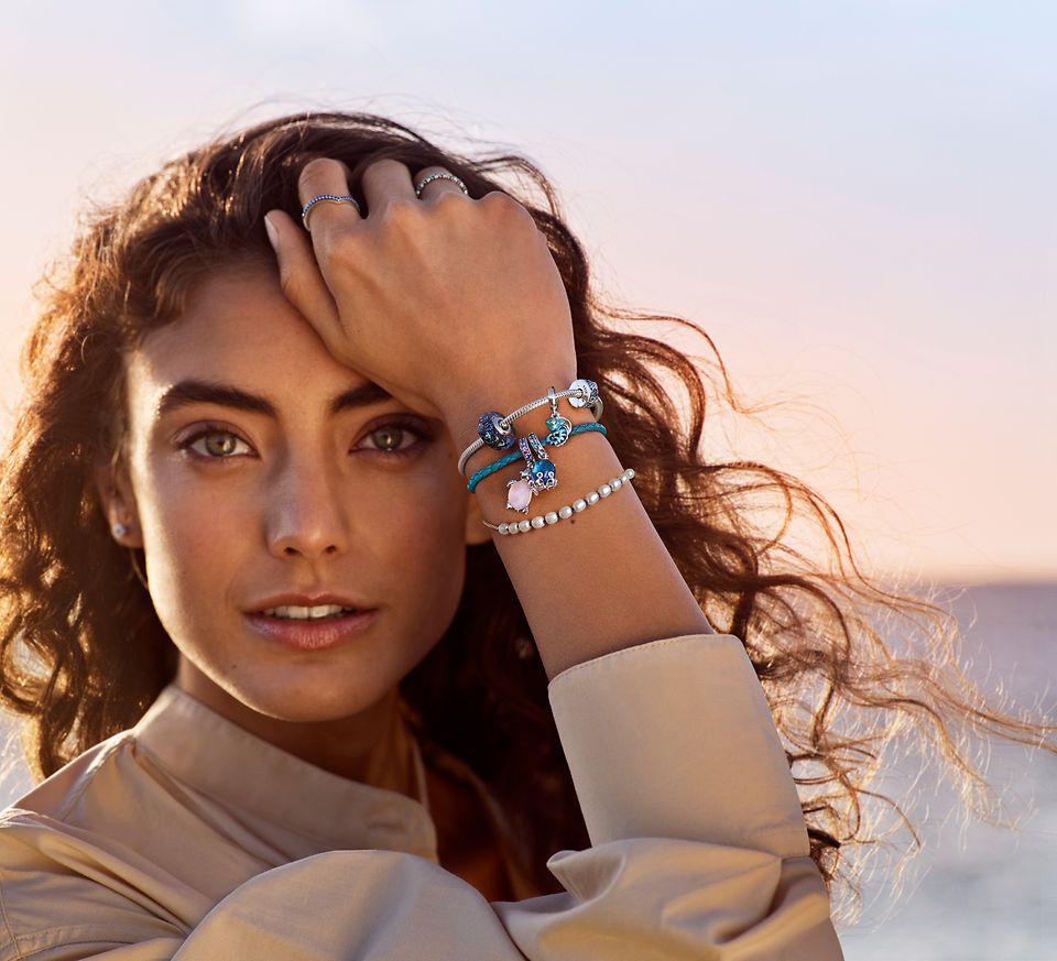 Femme portant 3 bracelets Pandora Moments avec des perles et des charms bleus