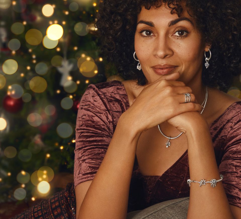 Una mujer llevando una pulsera navideña de Pandora Moments