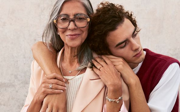 Un hijo abraza a su madre que lleva joyas de Pandora para el Día de la Madre