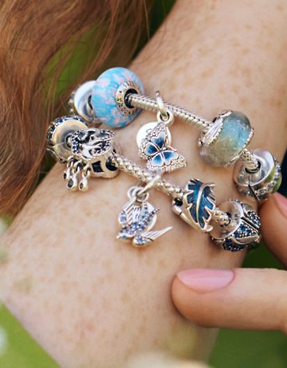 Mannequin portant des bracelets à charms printaniers Pandora Moments décorés de fleurs
