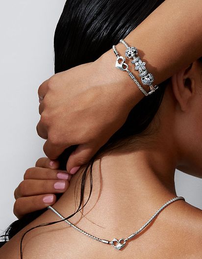 Femmes portant un collier à chaîne cloutée et deux bracelets en métaux mixtes