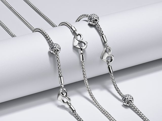 Bild av tre pärlade silverkedjor ur Pandora Moment-kollektionen bredvid varandra.