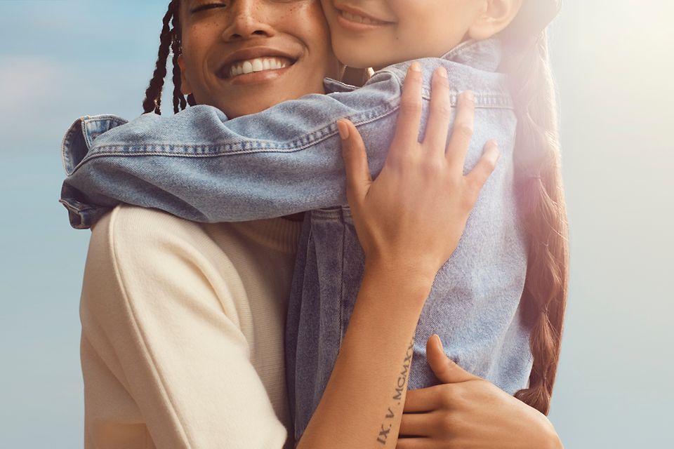 Image of a mother and daughter smiling and embracing.