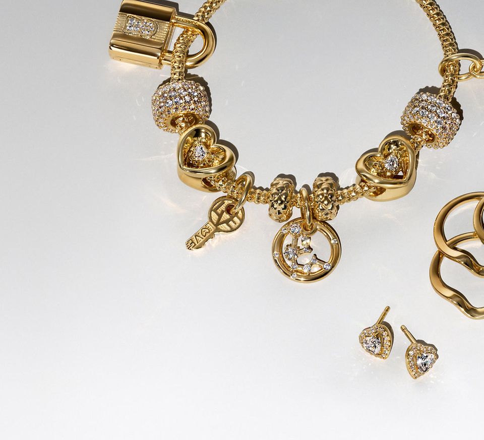 Zdjęcie przedstawiające złotą bransoletkę Pandora BE LOVE z diamentem wytworzonym w laboratorium i pięć kolczyków