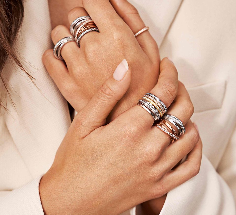 Dłoń modelki ozdobiona zestawem pierścionków ze srebra i Pandora Rose